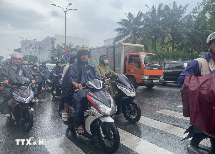 Các phương tiện lưu thông trên đường Hoàng Văn Thụ (phường Đức Nhuận) dưới cơn mưa trái mùa sáng 26/2/2026. (Ảnh: Hồng Đạt/TTXVN)