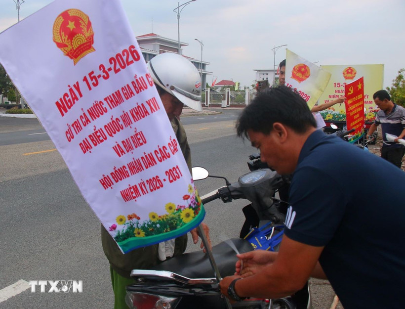 Gắn thông tin tuyên truyền bằng xe gắn máy trên địa bàn xã Vĩnh Viễn, thành phố Cần Thơ. (Ảnh: Duy Khương/TTXVN)