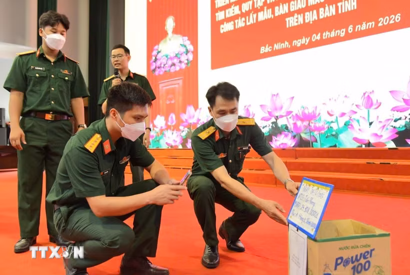 Hướng dẫn thao tác lấy mẫu hài cốt liệt sỹ tại buổi tập huấn. (Ảnh: Danh Lam/TTXVN)