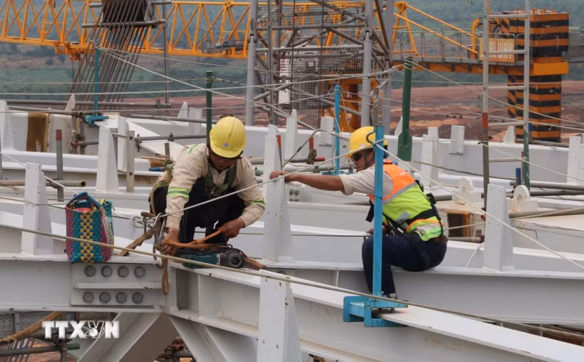 Người lao động hoàn thiện kết cấu thép mái nhà ga sân bay Long Thành. (Ảnh: Công Phong/TTXVN)