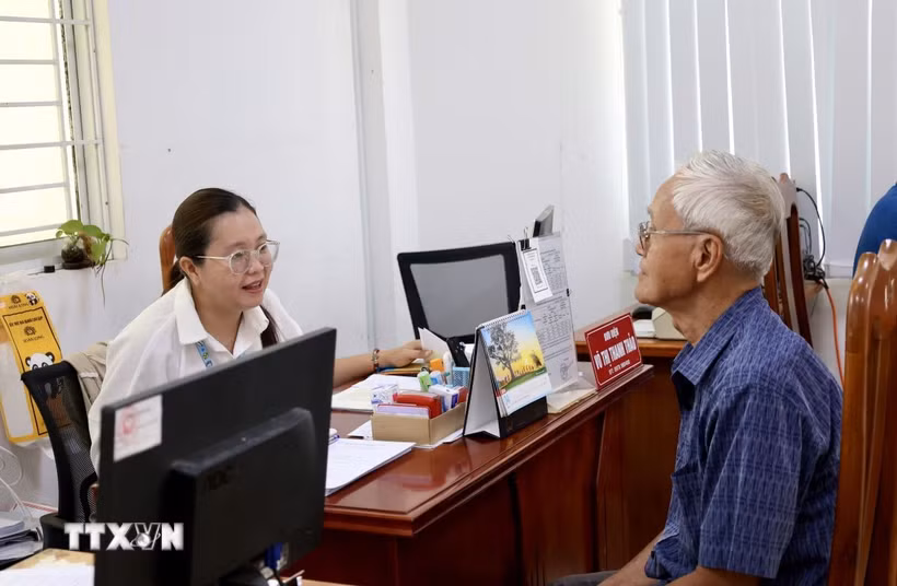 Cán bộ Trung tâm Phục vụ hành chính công phường Long Xuyên (An Giang) tận tình hướng dẫn người dân đến làm thủ tục hành chính. (Ảnh: Thanh Sang/TTXVN)
