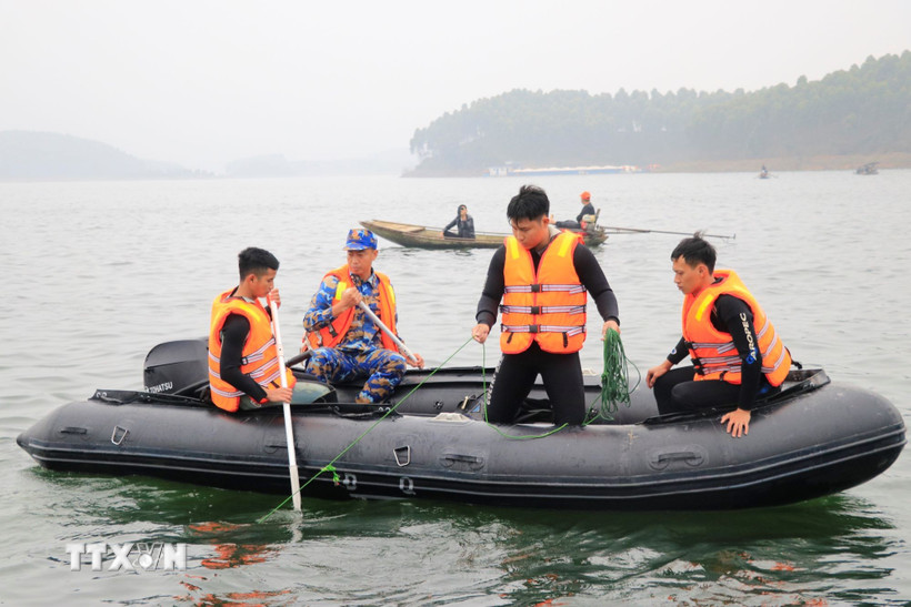 Lực lượng chức năng tìm kiếm các nạn nhân vụ chìm tàu khách tại hồ Thác Bà, Lào Cai ngày 22/2. (Ảnh: Đinh Thùy/TTXVN)