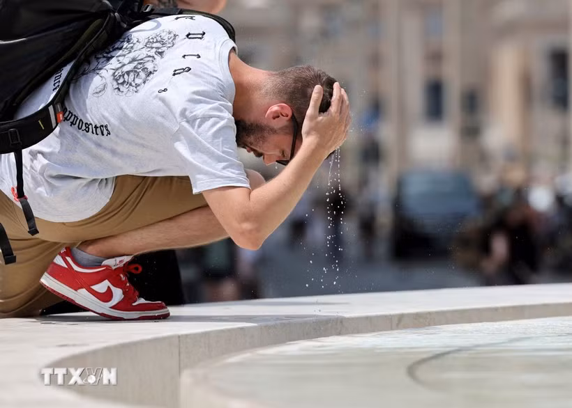 Một khách du lịch làm mát tại đài phun nước ở Rome, Italy. (Ảnh: THX/TTXVN phát)