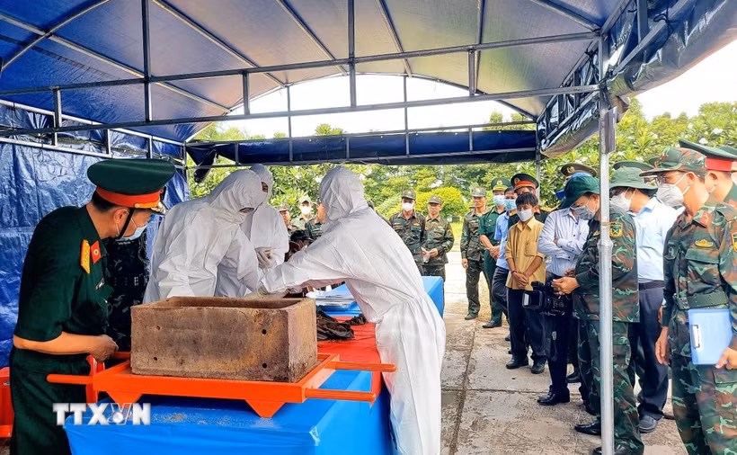 Lực lượng chức năng tiến hành lấy mẫu sinh phẩm để giám định ADN nhằm xác định thông tin liệt sỹ. (Ảnh: Công Mạo/TTXVN)