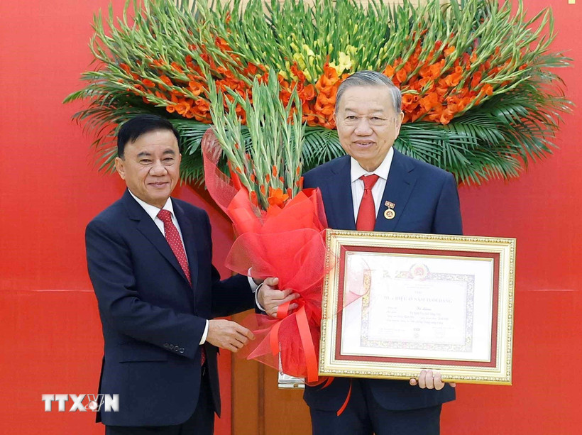 Đồng chí Trần Cẩm Tú, Ủy viên Bộ Chính trị, Thường trực Ban Bí thư trao Huy hiệu Đảng và tặng hoa chúc mừng Tổng Bí thư Tô Lâm. (Ảnh: Thống Nhất/TTXVN)