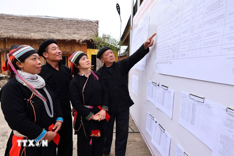 Cử tri xem danh sách đại biểu ứng cử được niêm yết công khai tại nhà văn hóa thôn Nặm Đăm, xã Quản Bạ. (Ảnh: Minh Đức/TTXVN)