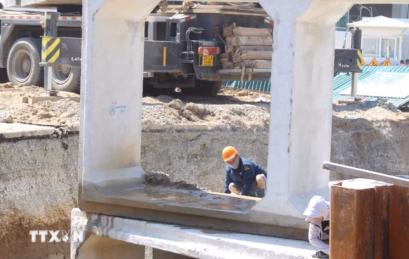 Vượt nắng nóng, công nhân thi công hạng mục chống ngập trên đường Hoàng Minh Thảo vẫn cần mẫn làm việc. (Ảnh: Nguyễn Thắng/TTXVN)