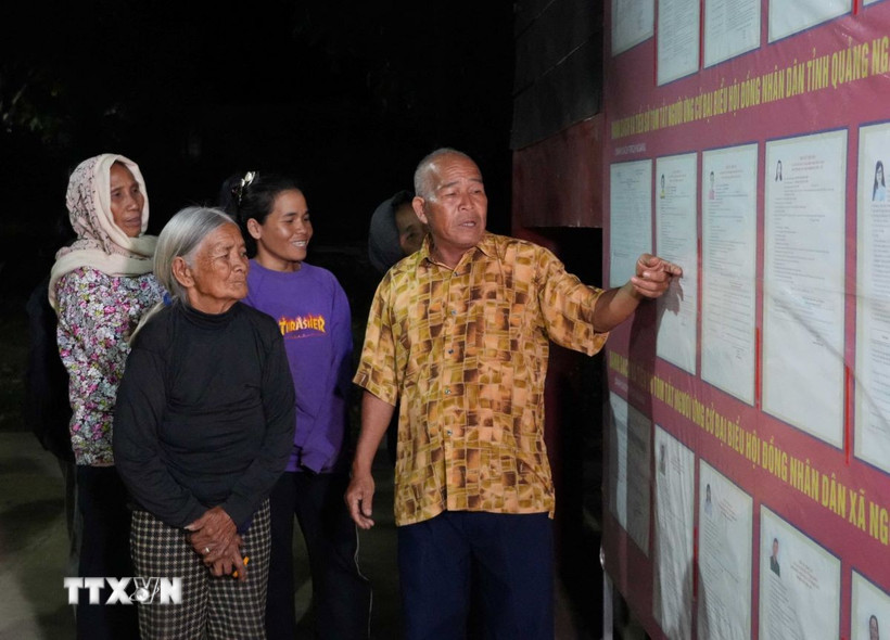 Đồng bào Công giáo thôn Plei Klêch, xã Ngọk Bay, tỉnh Quảng Ngãi, theo dõi thông tin đại biểu ứng cử. (Ảnh: Dư Toán/TTXVN)