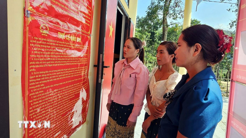 Đồng bào Bru-Vân Kiều (xã Trường Sơn, Quảng Trị) đọc các quy định về công tác bầu cử. (Ảnh: TTXVN phát)