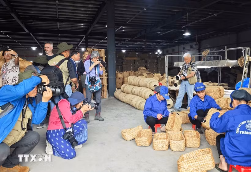 Các nhiếp ảnh gia tác nghiệp tại làng nghề cói Kim Sơn. (Ảnh: TTXVN phát)