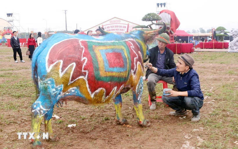 Các họa sỹ say sưa sáng tác trên mình trâu. (Ảnh: Nguyễn Chinh/TTXVN)