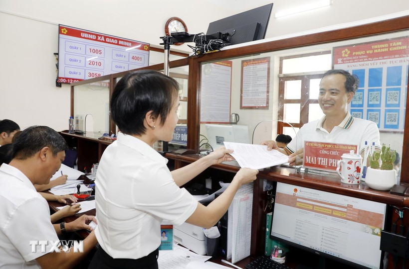 Cán bộ trao trả kết quả thủ tục hành chính cho người dân tại Trung tâm hành chính công xã. (Ảnh: Thái Thuần/TTXVN)