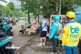 Hà Nội: Tài xế xe ôm công nghệ xếp hàng nhận biên bản vi phạm giao thông 