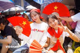 Ảnh người dân háo hức chờ đoàn diễu binh, diễu hành. (Ảnh: Vietnam+)