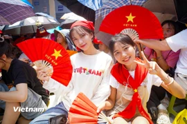 Ảnh người dân háo hức chờ đoàn diễu binh, diễu hành. (Ảnh: Vietnam+)