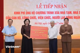 Thống đốc Ngân hàng Việt Nam, bà Nguyễn Thị Hồng trao số tiền ủng hộ từ đóng góp của người lao động ngành Ngân hàng tới Ủy ban Trung ương Mặt trận Tổ quốc Việt Nam. (Ảnh: Hoài Nam/Vietnam+)