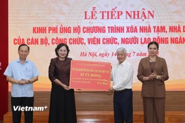 Thống đốc Ngân hàng Việt Nam, bà Nguyễn Thị Hồng trao số tiền ủng hộ từ đóng góp của người lao động ngành Ngân hàng tới Ủy ban Trung ương Mặt trận Tổ quốc Việt Nam. (Ảnh: Hoài Nam/Vietnam+)