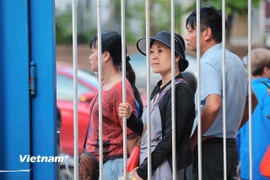 Phụ huynh hồi hộp, lo lắng khi các sỹ tử bước vào phòng thi làm bài môn đầu tiên trong kỳ thi THPT năm 2025. (Ảnh: Hoài Nam/Vietnam+)