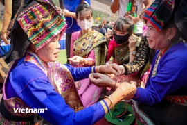 Tục buộc chỉ cổ tay cầu mong may mắn trong Lễ hội té nước hay còn gọi là Bun huột nặm của người Lào ở Điện Biên để chào đón năm mới. (Ảnh: Hoài Nam/Vietnam+)