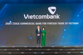 Bà Tô Thị Phương Dung - Trưởng Phòng Chính sách & Kế hoạch nhân sự đại diện Vietcombank nhận cúp "Harmonia" từ Ban tổ chức (ảnh trên) và chụp ảnh lưu niệm cùng đại diện lãnh đạo các đơn vị Vietcombank tham dự sự kiện (ảnh dưới). (Ảnh: Vietnam+)