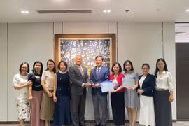 Đại diện Vietcombank, ông Vũ Quang Đông - Phó Giám đốc Khối phụ trách điều hành Khối vốn & Thị trường (đứng thứ 5 từ phải sang) nhận giải thưởng từ đại diện Ngân hàng J.P. Morgan Chase, ông Madhav Kalyan - Giám đốc Điều hành phụ trách Khối Dịch vụ thanh toán Khu vực Châu Á - Thái Bình Dương. (Ảnh: Vietnam+)