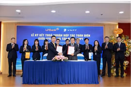 Ông Vũ Quốc Khánh, Tổng Giám đốc LPBank (trái) và ông Huỳnh Quang Liêm, Thành viên HĐTV kiêm Tổng Giám đốc Tập đoàn VNPT (phải) ký kết thoả thuận hợp tác toàn diện dưới sự chứng kiến của đại diện lãnh đạo hai bên. (Ảnh: Vietnam+)