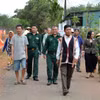 Già làng, người có uy tín trong cộng đồng và lực lượng biên phòng “đi từng ngõ, gõ từng nhà” để hướng dẫn người dân quy trình bỏ phiếu bầu cử đúng theo quy định. (Ảnh: Hồng Điệp/TTXVN)