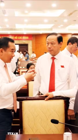 Ông Nguyễn Văn Được, Chủ tịch Ủy ban Nhân dân Thành phố Hồ Chí Minh, trao đổi với ông Võ Văn Minh, Chủ tịch Hội đồng Nhân dân Thành phố. (Ảnh: Xuân Khu/TTXVN)