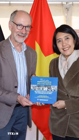 Đại sứ Nguyễn Hương Trà trao tặng cuốn sách "Tình cảm của nhân dân thế giới với Chủ tịch Hồ Chí Minh" cho Phó Tổng Thư ký Đảng Lao động Bỉ (PTB) Benjamin Pestieau tại gian hàng Việt Nam, ManiFiesta 2026. (Ảnh: Anh Tùng/TTXVN)