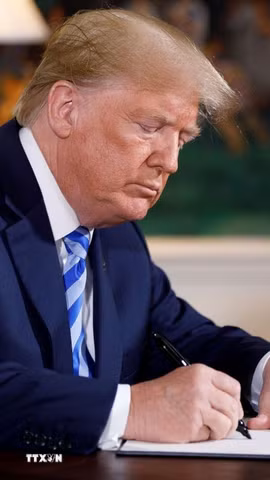 Tổng thống Mỹ Donald Trump ký sắc lệnh tại Nhà Trắng. (Ảnh: THX/TTXVN phát)