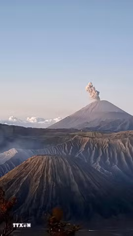 Núi lửa Semeru phun cột tro, trong khi khói bốc lên từ miệng núi lửa Bromo, thuộc quần thể núi lửa Tengger, tỉnh Đông Java, Indonesia. (Ảnh: Đỗ Quyên/TTXVN)