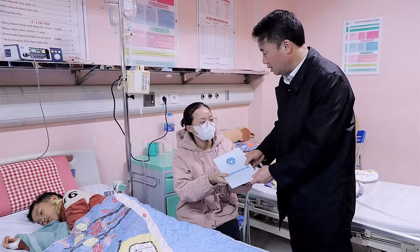 Tổng Giám đốc Bảo hiểm Xã hội Việt Nam Nguyễn Thế Mạnh tặng quà cho bệnh nhi đang điều trị tại Bệnh viện Nhi Trung ương. (Ảnh: PV/Vietnam+)