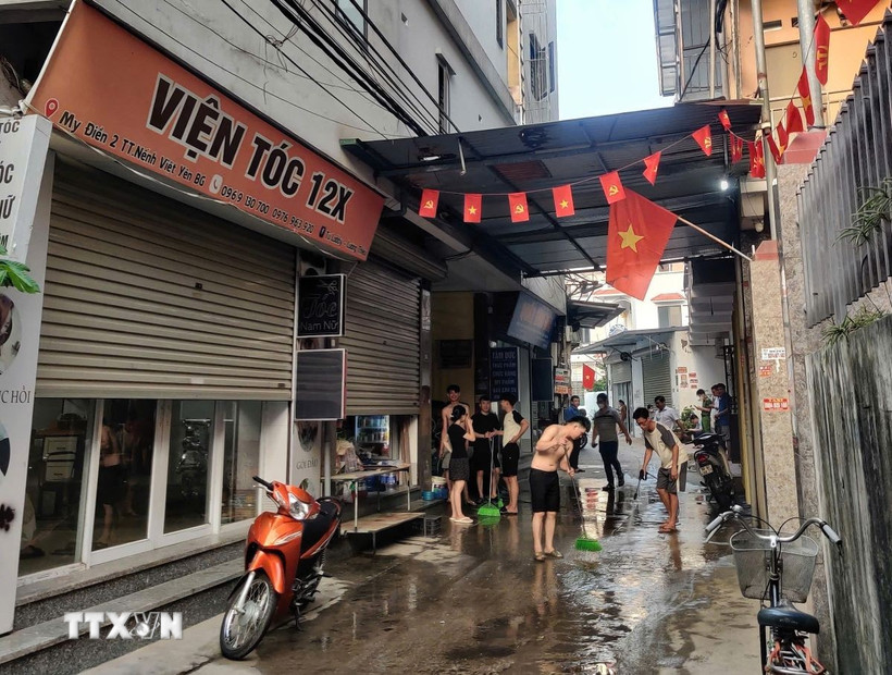 Người dân dọn dẹp hiện trường vụ nổ. (Ảnh: TTXVN phát)