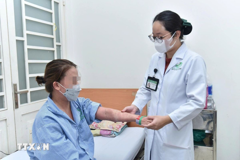 Bác sỹ Bệnh viện Quân y 175 khám cho người bệnh sau hai tuần điều trị tích cực tại bệnh viện. (Ảnh: TTXVN phát)