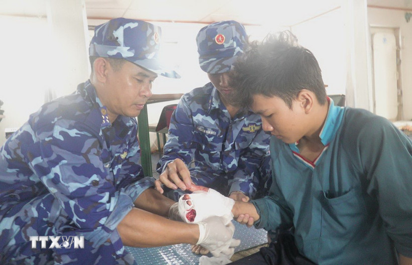 Tổ Quân y Hải đội 401 (Bộ Tư lệnh Vùng Cảnh sát biển 4) tiến hành sơ cứu cho nạn nhân. (Ảnh: TTXVN phát)