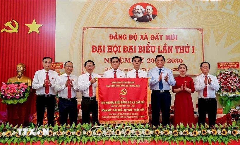 Thay mặt Tỉnh ủy, Phó Chủ tịch UBND tỉnh Cà Mau Lâm Văn Bi (thứ 3 từ phải sang), trao tặng Đại hội bức trướng mang dòng chữ "Đoàn kết-Dân chủ-Đột phá-Phát triển" khai thác lợi thế, phát triển Đất Mũi thành đô thị sinh thái hiện đại ở cực Nam của Tổ quốc. (Ảnh TTXVN phát)