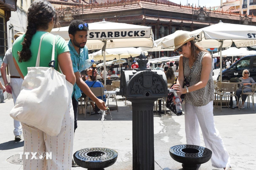 Người dân làm mát tại vòi nước công cộng dưới trời nắng nóng ở Madrid, Tây Ban Nha ngày 29/5/2025. (Ảnh: THX/TTXVN)