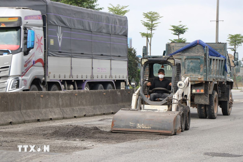 Thu gom lớp áo đường bị hư hỏng. (Ảnh: Mai Trang/TTXVN)