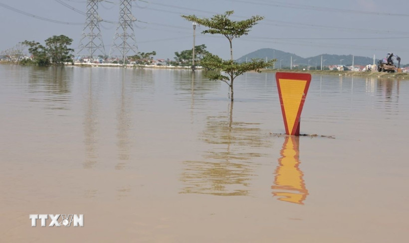 Những tuyến giao thông, biển báo chìm trong biển nước. (Ảnh: Trần Việt/TTXVN)