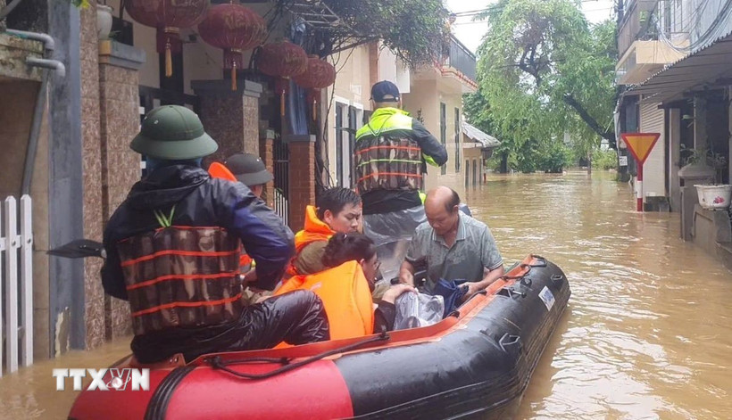 Công an thành phố Huế hỗ trợ, di dời người dân phường An Cựu ra khỏi vùng ngập lụt. (Ảnh: TTXVN phát)