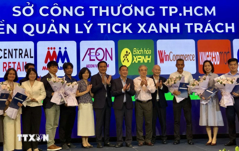 Đại diện Sở Công thương Thành phố Hồ Chí Minh thực hiện nghi thức trao quyền kiểm soát sản phẩm Tick xanh trách nhiệm cho 11 hệ thống phân phối. (Ảnh: Mỹ Phương/TTXVN)