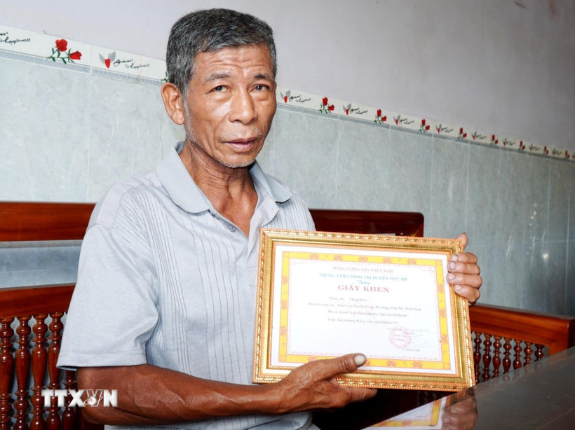 Ông Phạm Hào được Trung tâm Chính trị huyện Phù Mỹ tặng Giấy khen. (Ảnh: Lê Phước Ngọc/TTXVN)