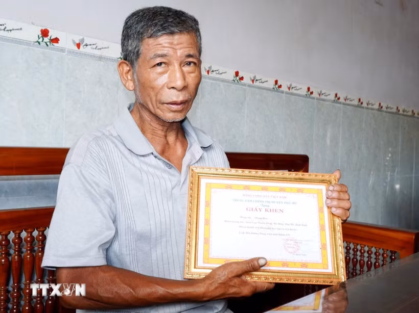 Ông Phạm Hào được Trung tâm Chính trị huyện Phù Mỹ tặng Giấy khen. (Ảnh: Lê Phước Ngọc/TTXVN)