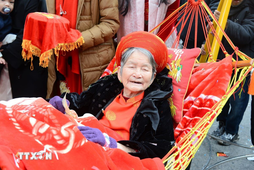 Cụ bà 90 tuổi phấn khởi khi được tham gia lễ rước lên miếu Tiên Công. (Ảnh: Thanh Vân/TXTVN)