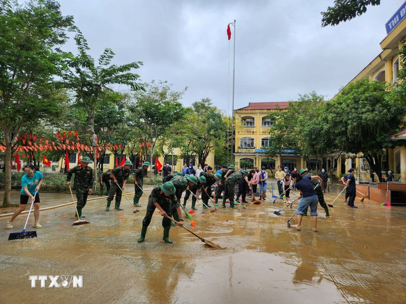 Các chiến sỹ Trung đoàn 6, Bộ Chỉ huy Quân sự thành phố Huế hỗ trợ nhân dân dọn dẹp vệ sinh sau mưa lũ. (Ảnh: Mai Trang/TTXVN)