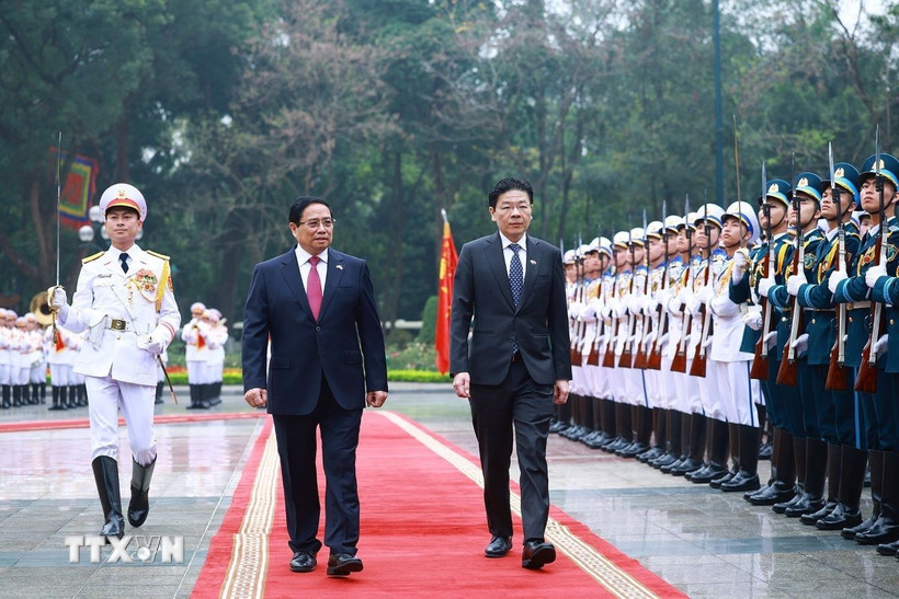 Thủ tướng Phạm Minh Chính và Thủ tướng Singapore Lawrence Wong duyệt Đội danh dự Quân đội nhân dân Việt Nam. (Ảnh: Dương Giang/TTXVN)