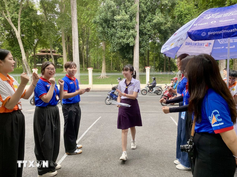 Mỗi thí sinh đến điểm thi đều nhận được tràng pháo tay động viên và những lời chúc may mắn từ các anh chị sinh viên, đoàn viên tình nguyện. (Ảnh: Hồng Giang/TTXVN)