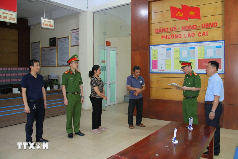 Lực lượng chức năng đọc lệnh khởi tố các đối tượng sản xuất giá đỗ bằng hóa chất độc. (Ảnh TTXVN phát)