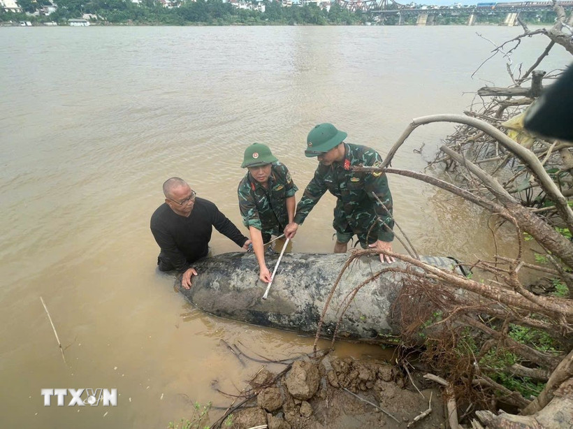 Lực lượng chức năng đo kích thước 2 quả bom. (Ảnh: TTXVN phát)