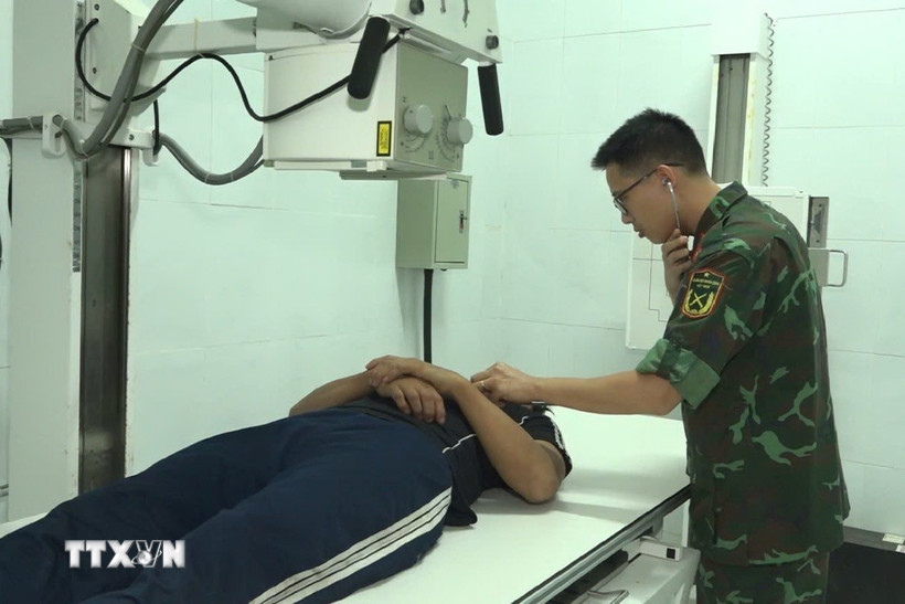 Bác sỹ Bệnh xá Đảo Song Tử Tây đang thăm khám cho bệnh nhân Đặng Ân. (Ảnh: TTXVN phát)